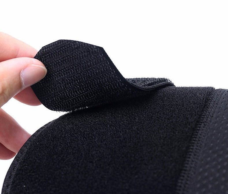 A hand opening the adjustable velcro strap of a black Fitlybuy dual shoulder compression support wrap.