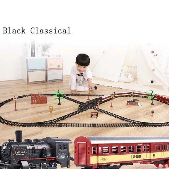 Fitlybuy 39-piece black model train set with oval tracks, buildings, and a child playing on a floor.