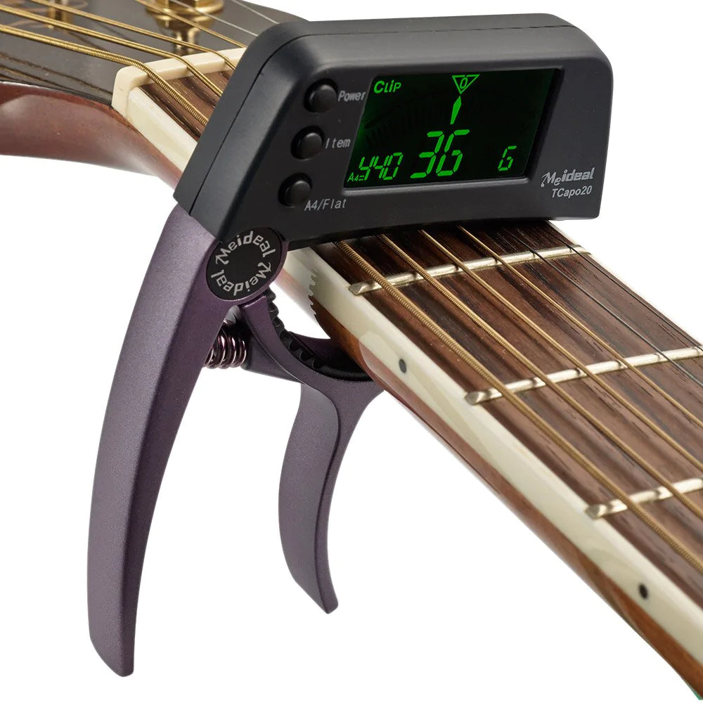 Purple 2-in-1 guitar capo and digital tuner clipped onto a guitar neck with a green illuminated display.