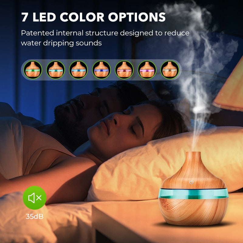 Wood grain aroma diffuser emitting mist next to a couple sleeping in a quiet bedroom with 7 LED light options.