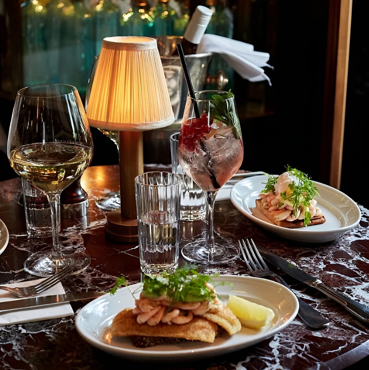 Fitlybuy dimmable vintage brass LED lamp with pleated shade on a restaurant table with drinks and appetizer plates.
