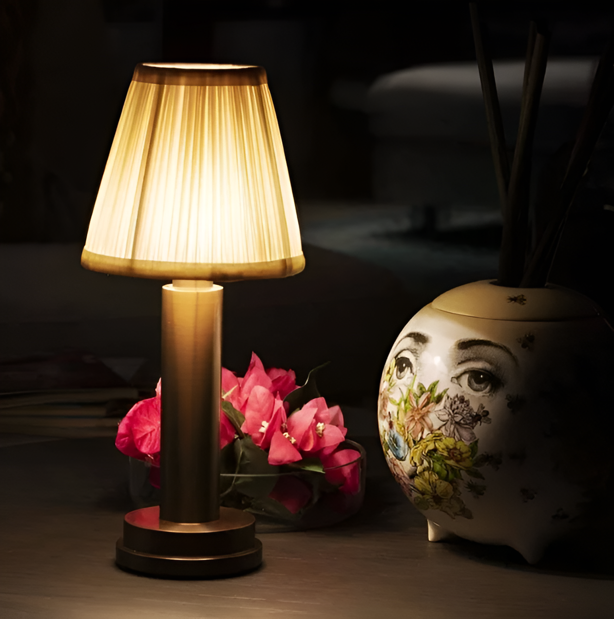 Fitlybuy dimmable vintage gold aluminium lamp with a beige pleated shade glowing on a dark table next to decor.