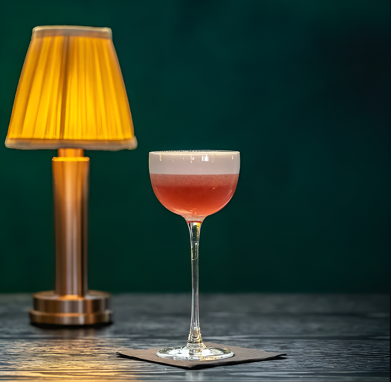 Fitlybuy vintage dimmable aluminium table lamp with golden fabric shade next to a cocktail on a dark wooden table.