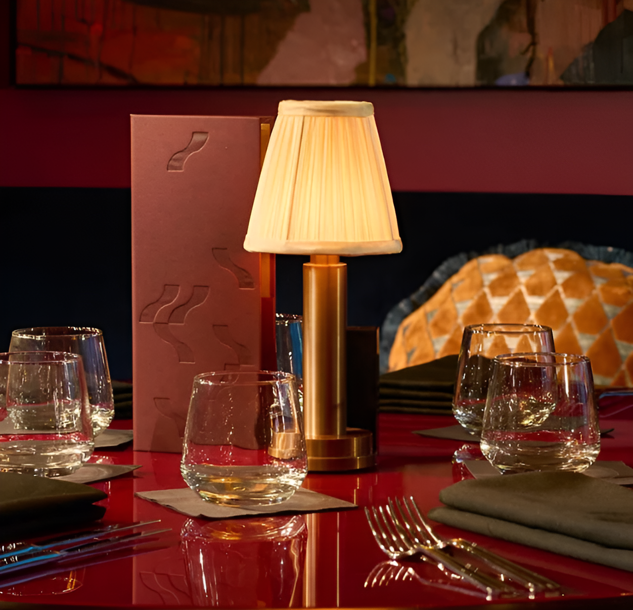 Fitlybuy vintage dimmable gold aluminium table lamp with cream fabric shade on a restaurant table with glasses.