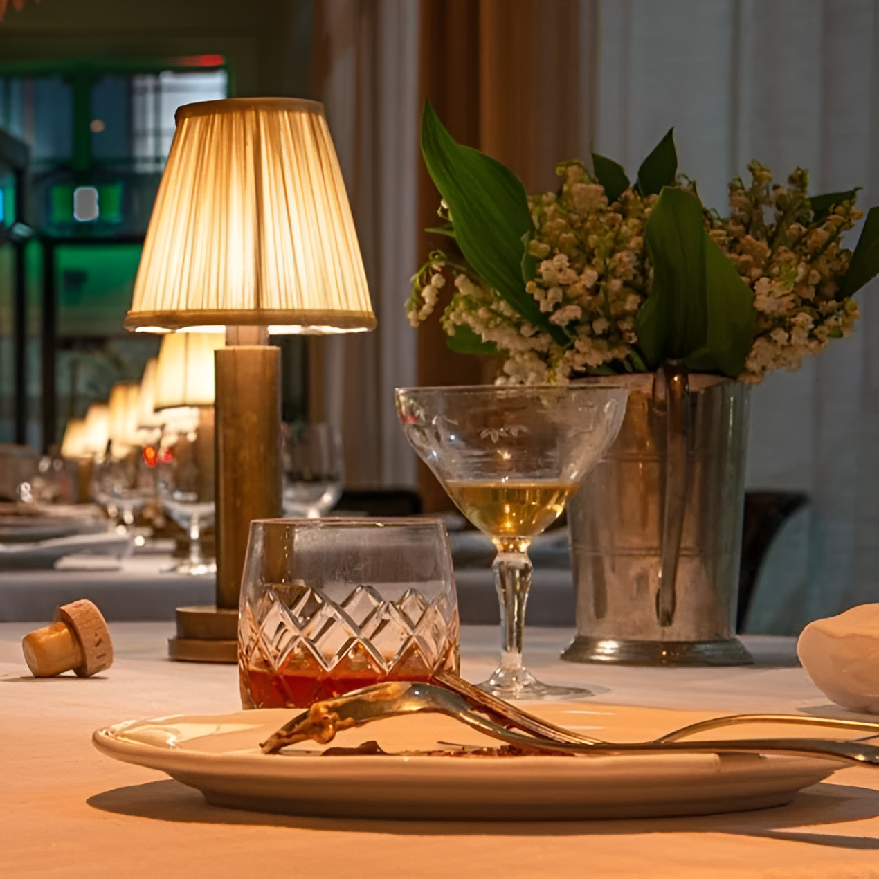 Fitlybuy vintage dimmable aluminium table lamp with warm LED glow, fabric shade, on a restaurant table with dinnerware.