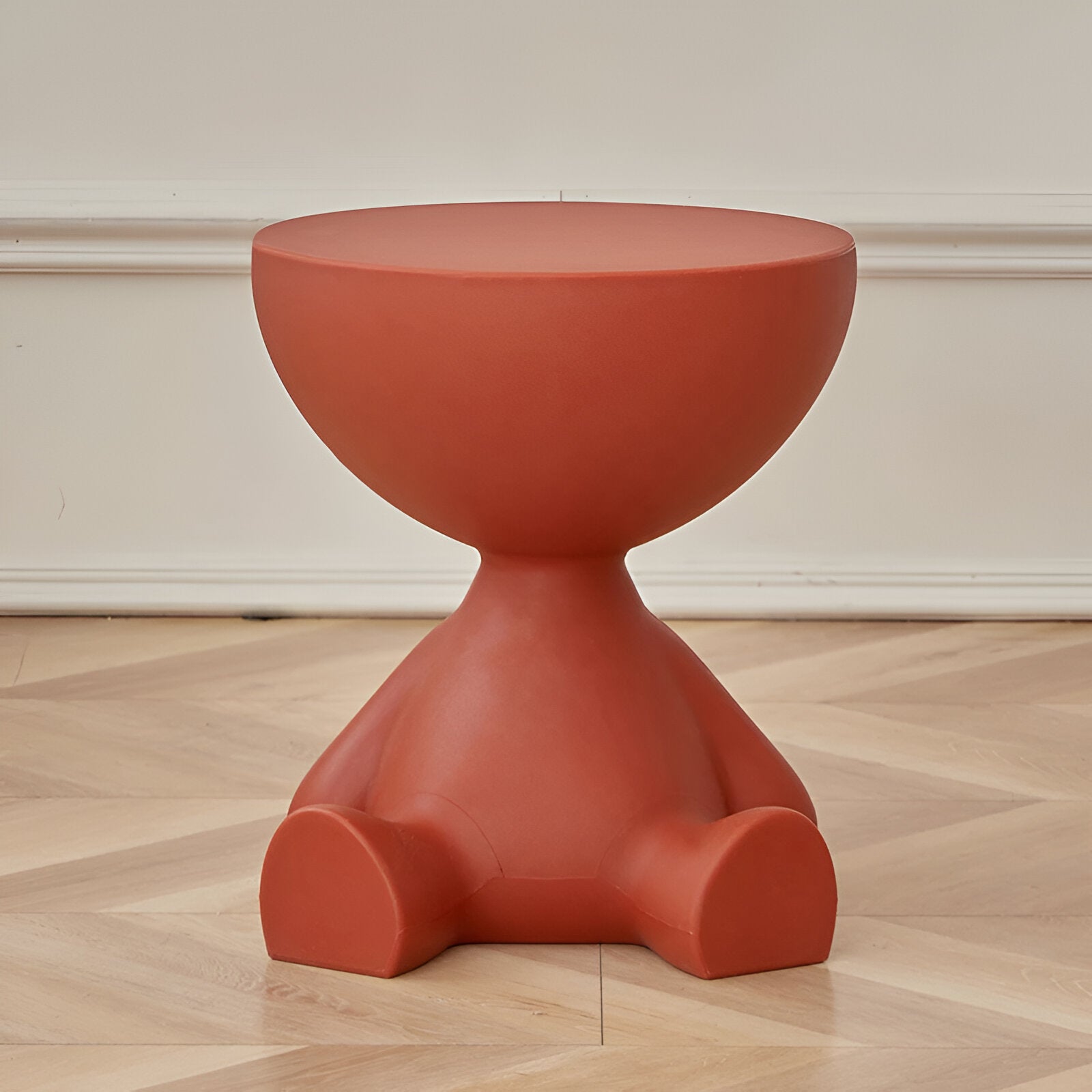 Fitlybuy Ylix terracotta-colored round coffee table with a sculptural, seated figure-shaped base on hardwood floors.