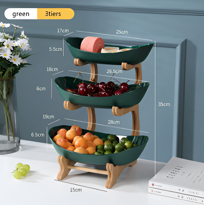 Fitlybuy 3-tier dark green bowl stand with a light wood frame, filled with assorted fruits on a white table.