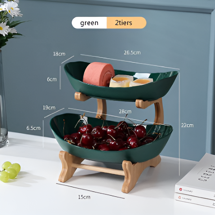 Fitlybuy green 2-tier fruit bowl with wooden stand, displaying snacks and cherries on a table with dimension labels.