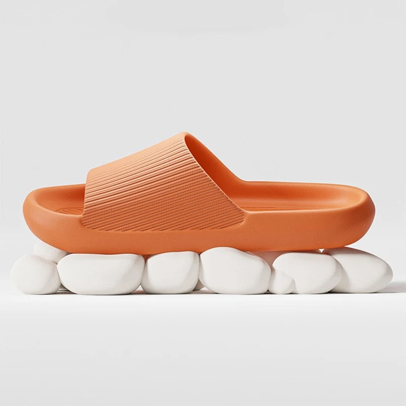 Orange Fitlybuy Cloud Slides with ComfortFoam cushioning, featured on a white stone base against a plain background.