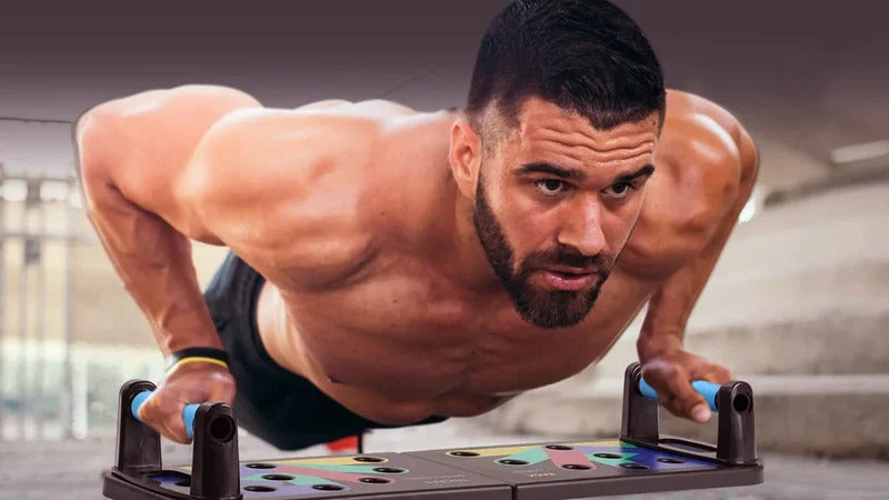Fitlybuy folding push-up board with blue ergonomic grips and color-coded exercise zones used by an athlete.