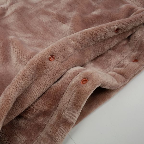 Close-up of a soft, dusty rose flannel cordless heated blanket featuring snap buttons for secure closure.