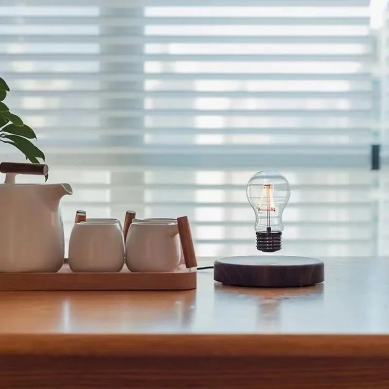 Fitlybuy Levion levitating Tesla lamp with a glowing lightbulb floating above a dark wood base on a desk.