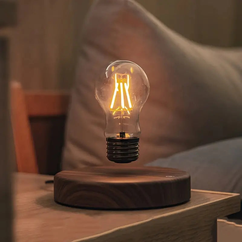 Fitlybuy Levion levitating Tesla lamp with a glowing LED Edison bulb floating over a wooden base on a nightstand.