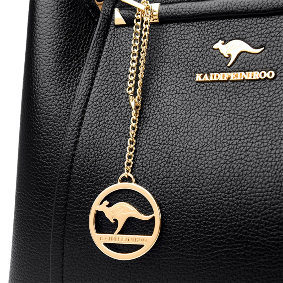 Black pebbled PU leather shoulder bag featuring a gold kangaroo logo, hardware, and a matching circular charm.