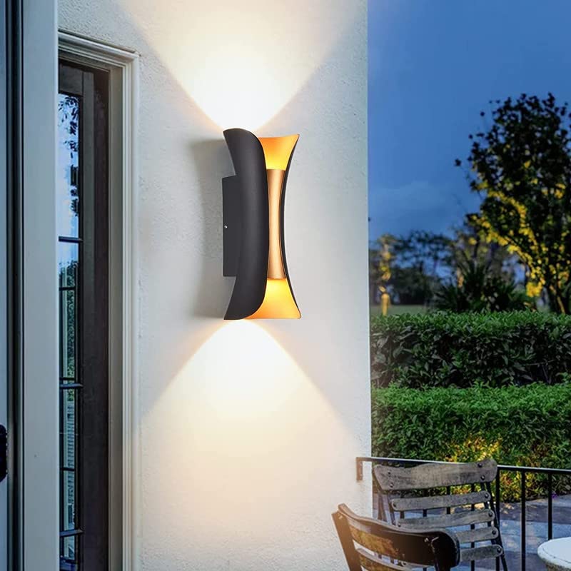 Fitlybuy Lumio modern black and gold waterproof LED wall light casting up-and-down beams on a patio wall at dusk.