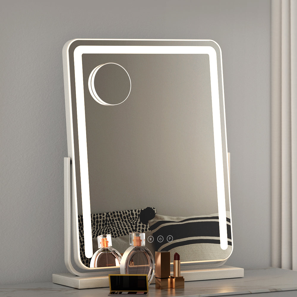 Sheesha LED rectangular makeup mirror with 10X magnification, touch controls, and white frame on a vanity table.