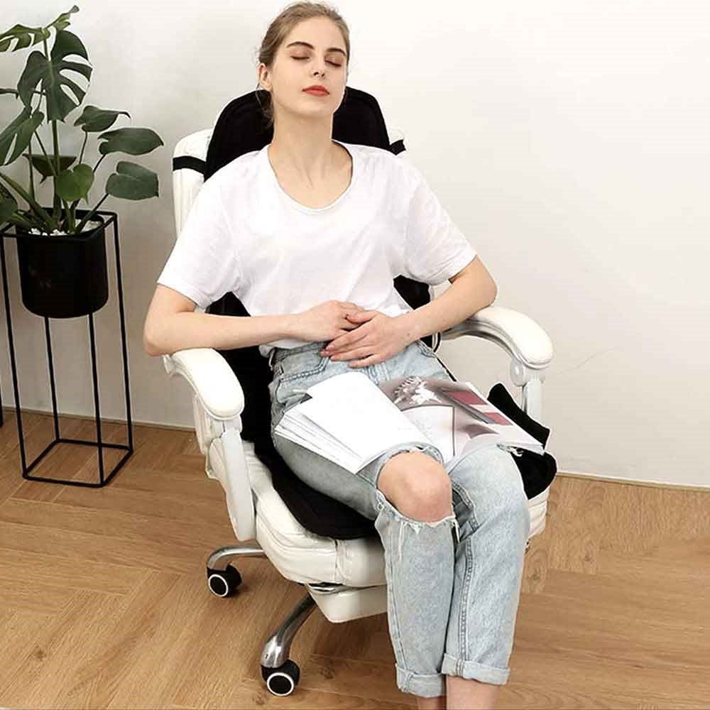 Woman relaxing in a white chair using a black Fitlybuy 8-mode heated massage pad with ComfortWave heat technology.