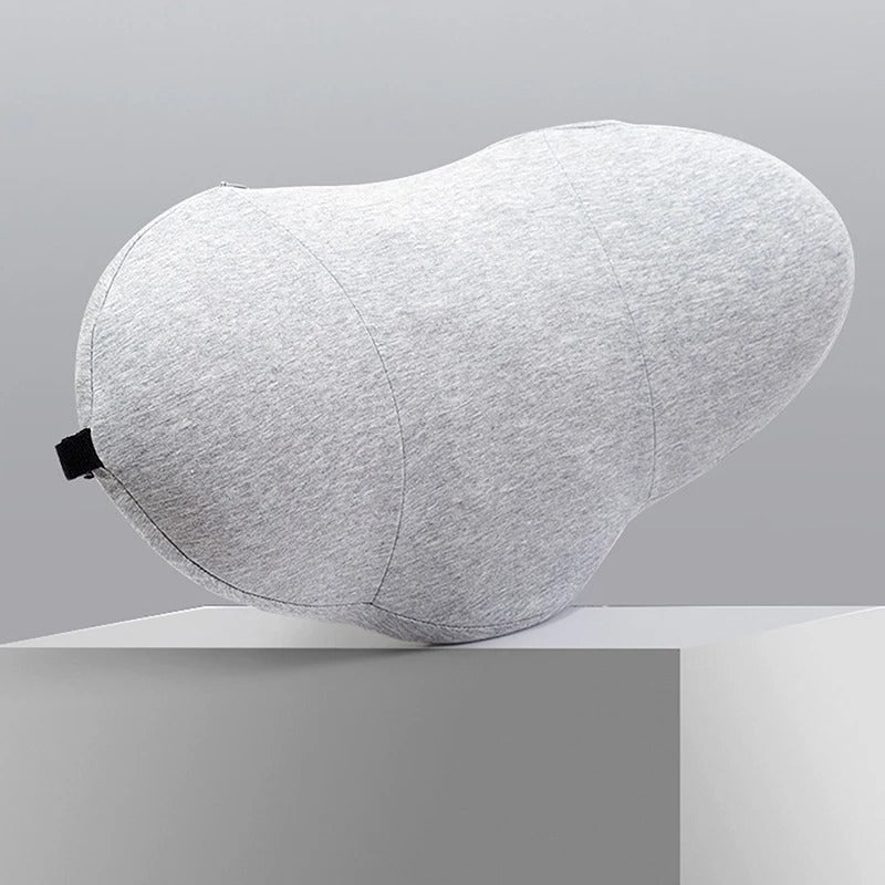 Gray Fitlybuy memory foam lumbar pillow with an ergonomic, contoured shape, resting on a white pedestal.