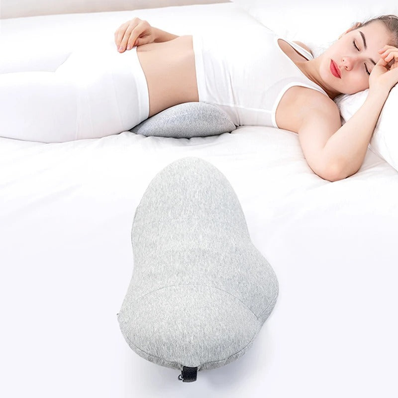 Fitlybuy gray ergonomic memory foam lumbar pillow, shown supporting a woman's lower back while lying on a white bed.