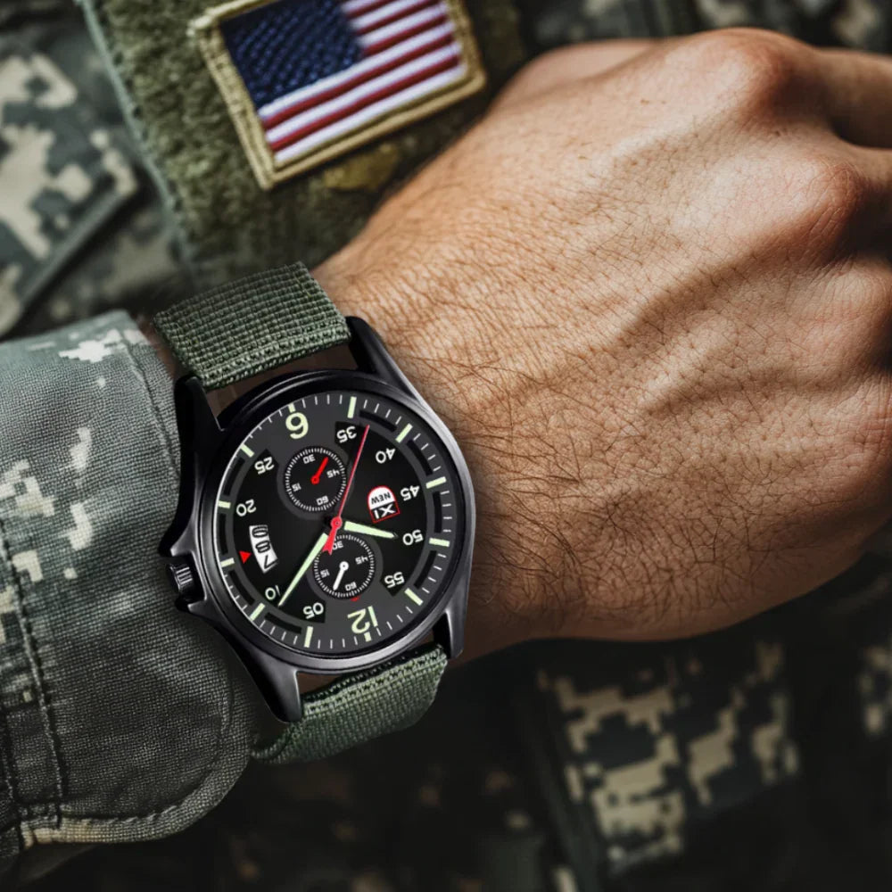 Fitlybuy tactical military quartz watch with black dial and olive nylon strap on a soldier's wrist with US flag patch.