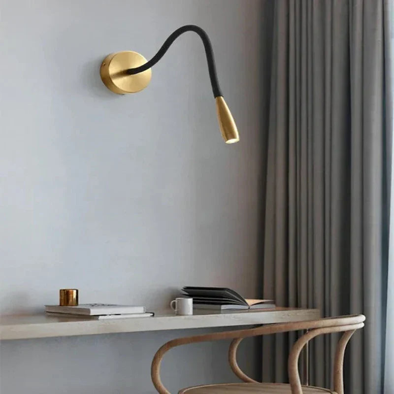 Fitlybuy TrendyShine adjustable gold and black wall lamp with LED light above a desk in a modern room.