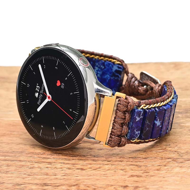 Fitlybuy smart watch with ethnic blue natural stone, gold chain, and brown woven band on a wooden surface.