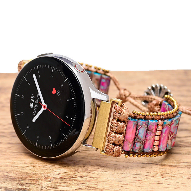 Fitlybuy cylindrical bracelet watch with a woven band featuring purple and blue natural stones on a wooden surface.