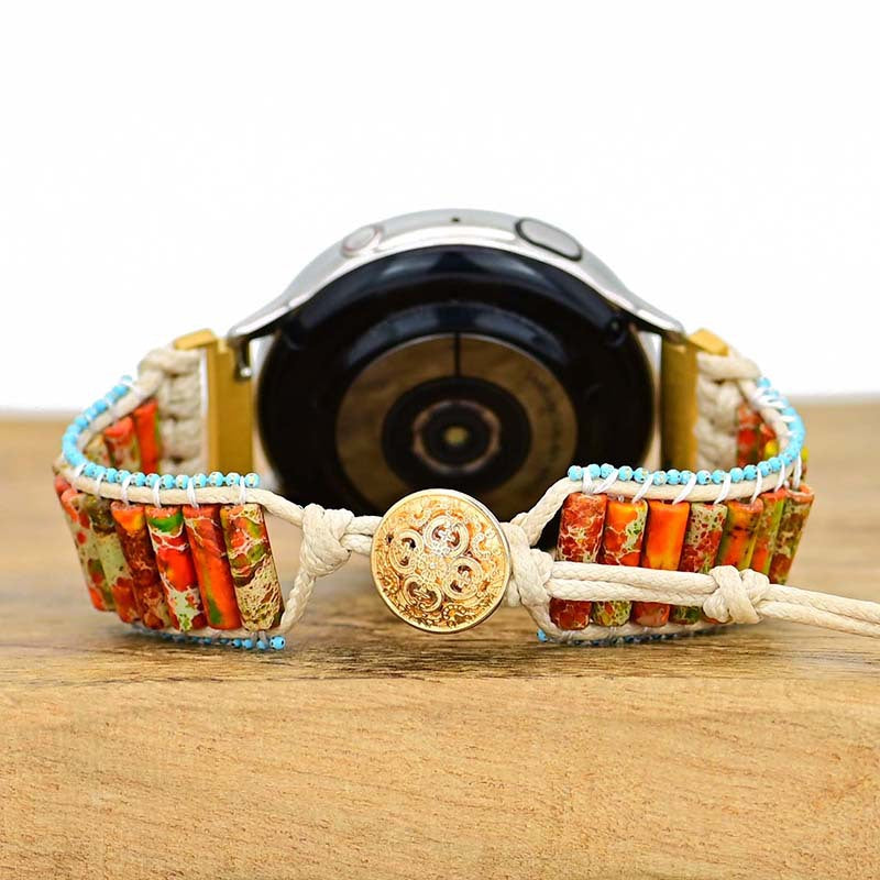 Smartwatch with retro ethnic woven band featuring orange and green cylindrical stones, blue beads, and gold-tone button.