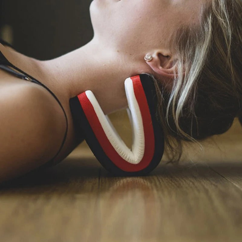 Woman lying on floor using a black, red, and white Fitlybuy orthopedic neck stretcher for ergonomic neck support.