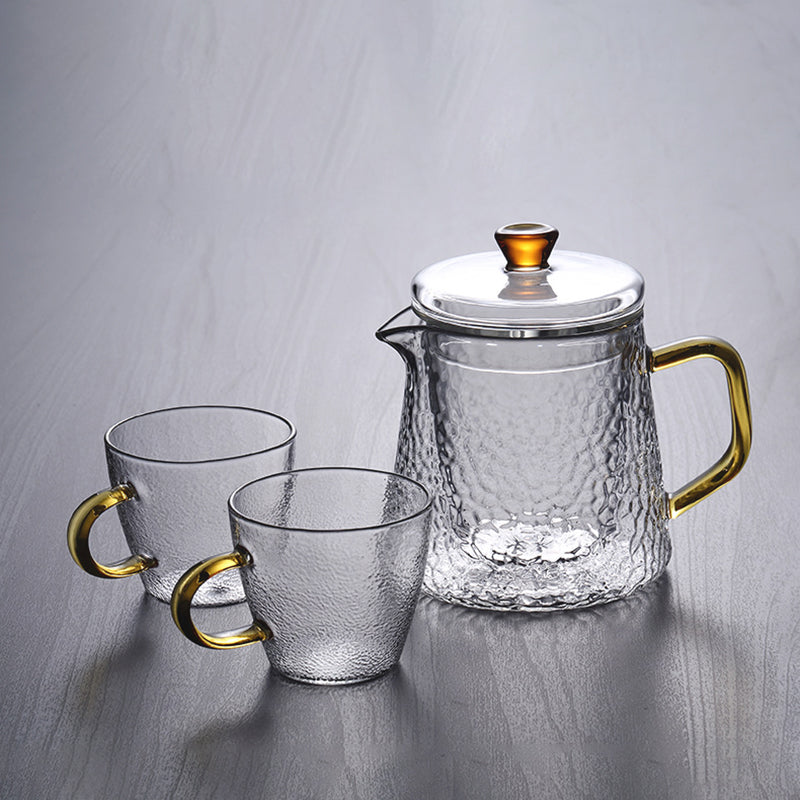 Fitlybuy Pindefang hammered glass teapot and two matching cups with elegant gold handles on a grey surface.