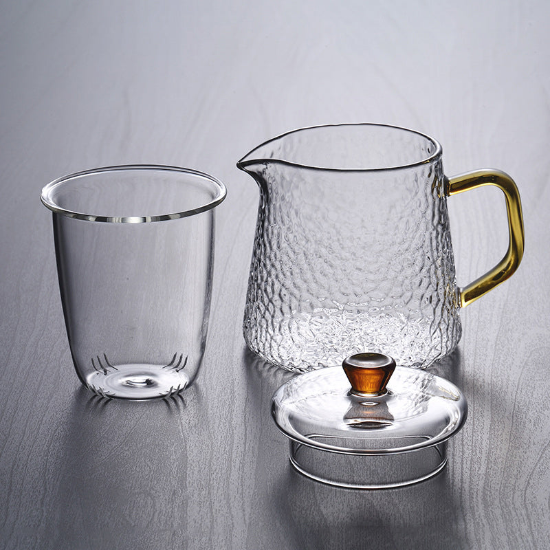 Fitlybuy Pindefang glass teapot with infuser, hammered texture, and golden handle on a grey surface.