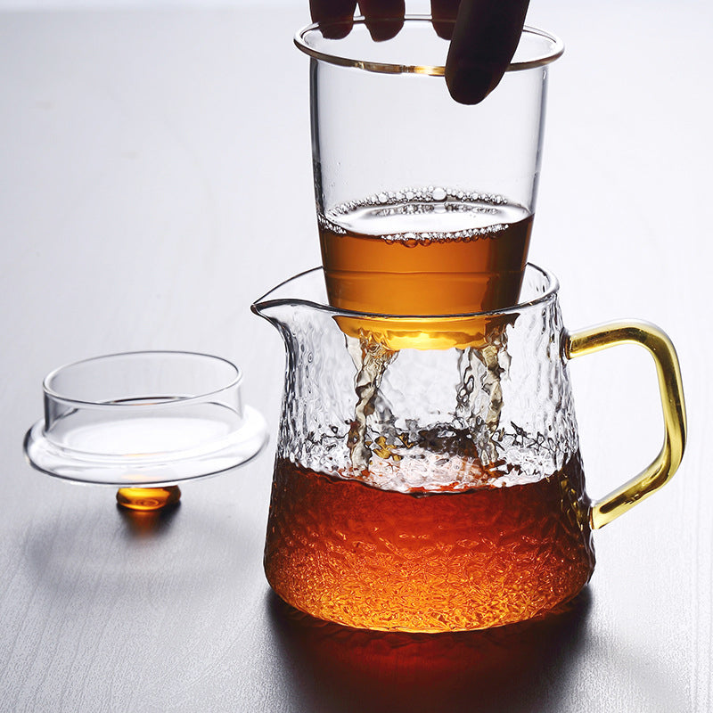 Fitlybuy Pindefang hammered glass teapot with golden handle, infuser, and lid, showing tea brewing on a table.