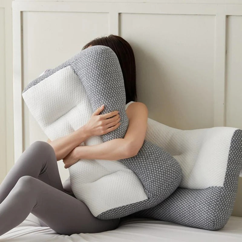 Woman hugging a grey and white ergonomic Fitlybuy pain relief pillow with adaptive foam on a bed.