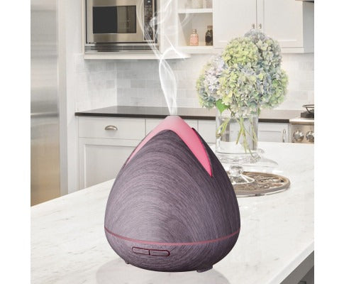 Fitlybuy PureSpa dark wood grain ultrasonic diffuser with pink light, emitting cool mist on a kitchen counter.