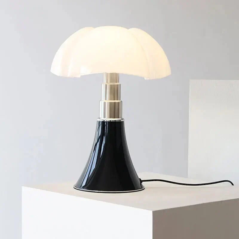 Fitlybuy FloraLuxe LED table lamp with a white flower-shaped shade, silver stem, and glossy black cone base on a plinth.