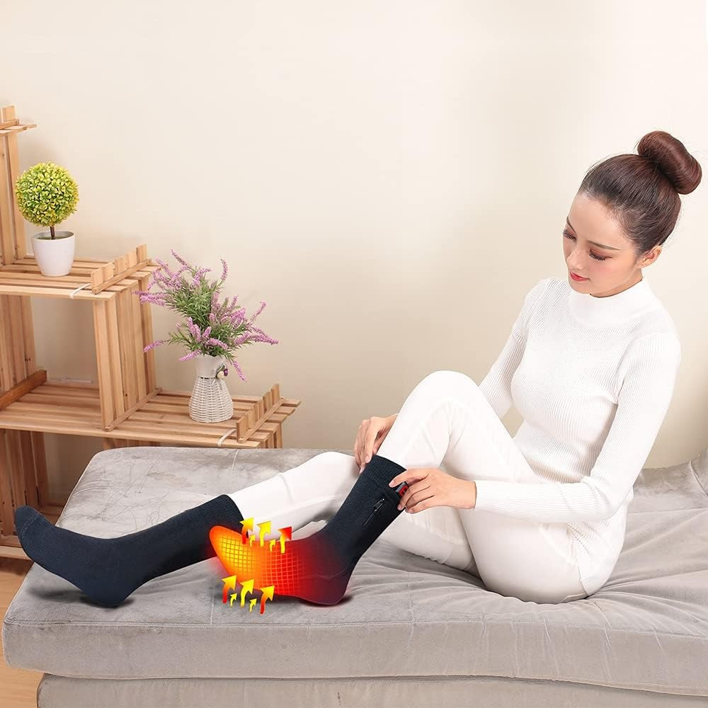 Woman wearing black Fitlybuy electric heated socks featuring ThermoFlex heat technology on her feet while sitting indoors.