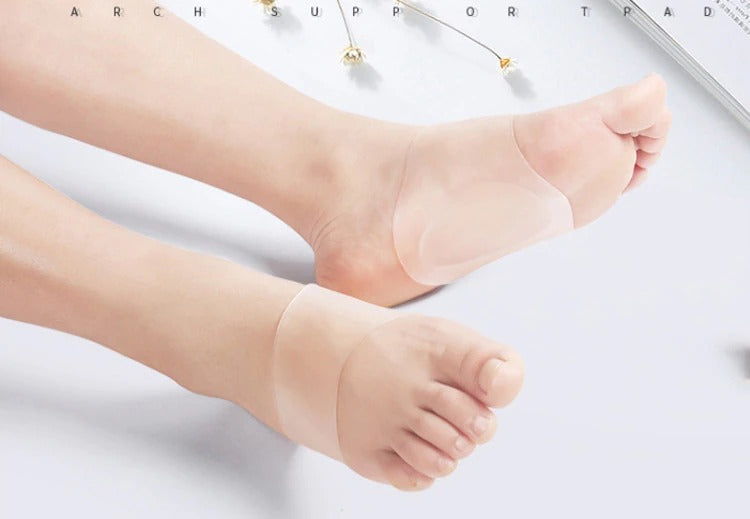 Beige silicone ComfortFlex arch support pads worn on feet to provide flat foot cushioning.