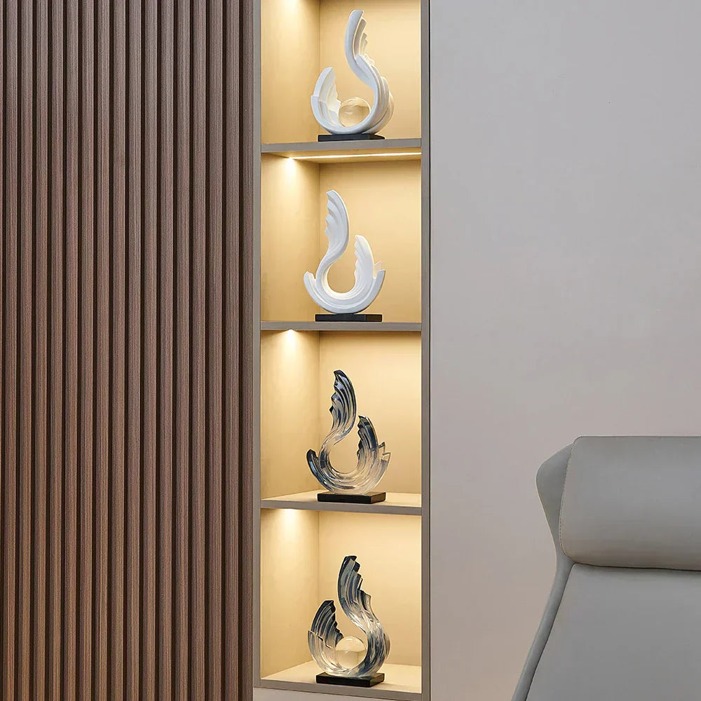 Fitlybuy Ethereal Flow glass ornaments in white and blue, featuring fluid abstract designs on a lit wooden display shelf.