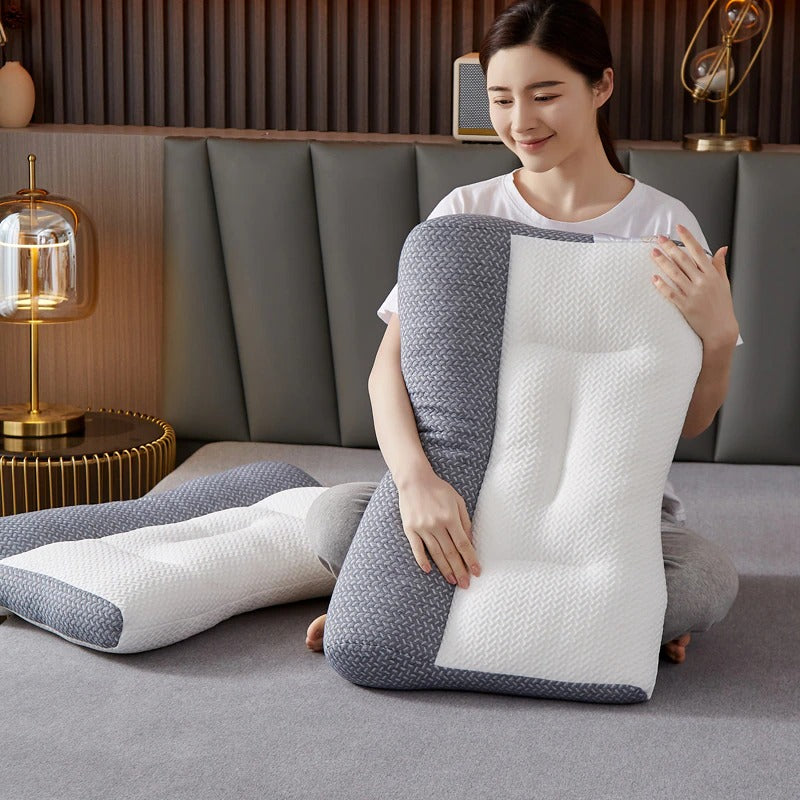 Woman holding a gray and white ergonomic Fitlybuy pain relief pillow with textured adaptive comfort foam on a bed.