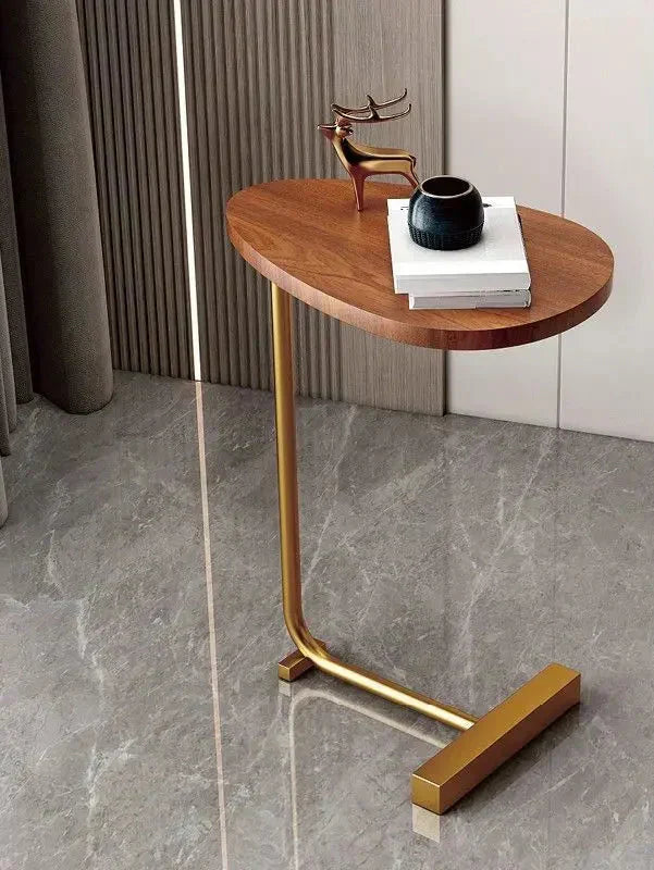 Fitlybuy oval wooden side table with a gold metal C-frame base on a marble floor, styled with a gold deer and books.