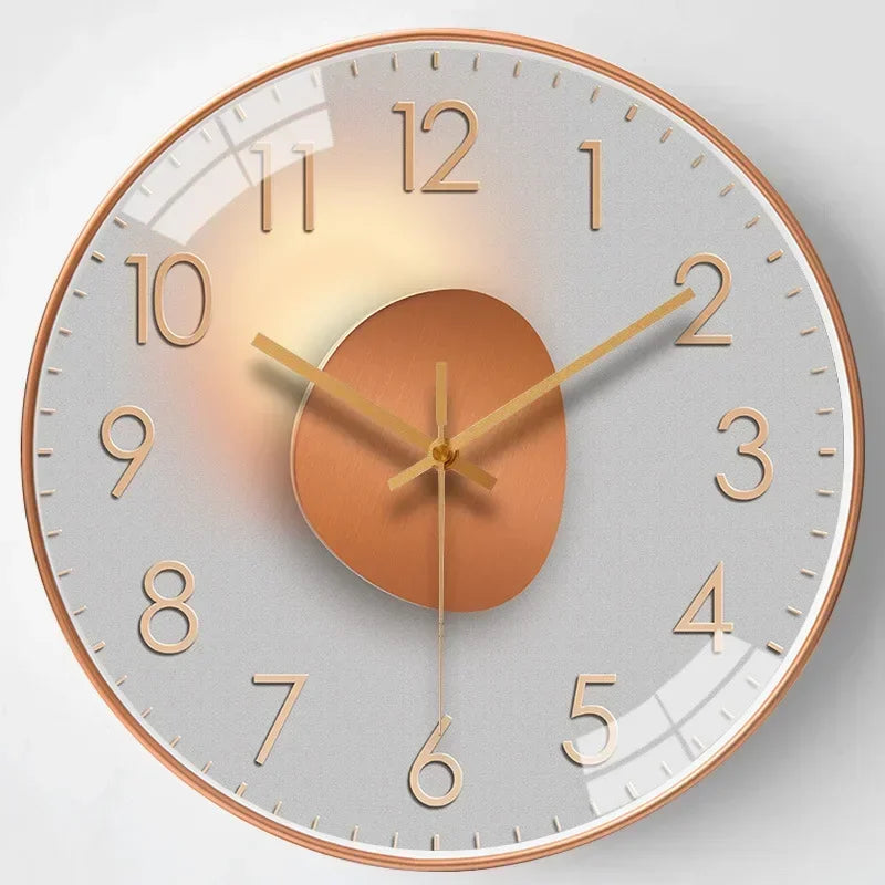 Fitlybuy silent wall clock with a rose gold frame, grey face, metallic gold numerals, and abstract copper center.