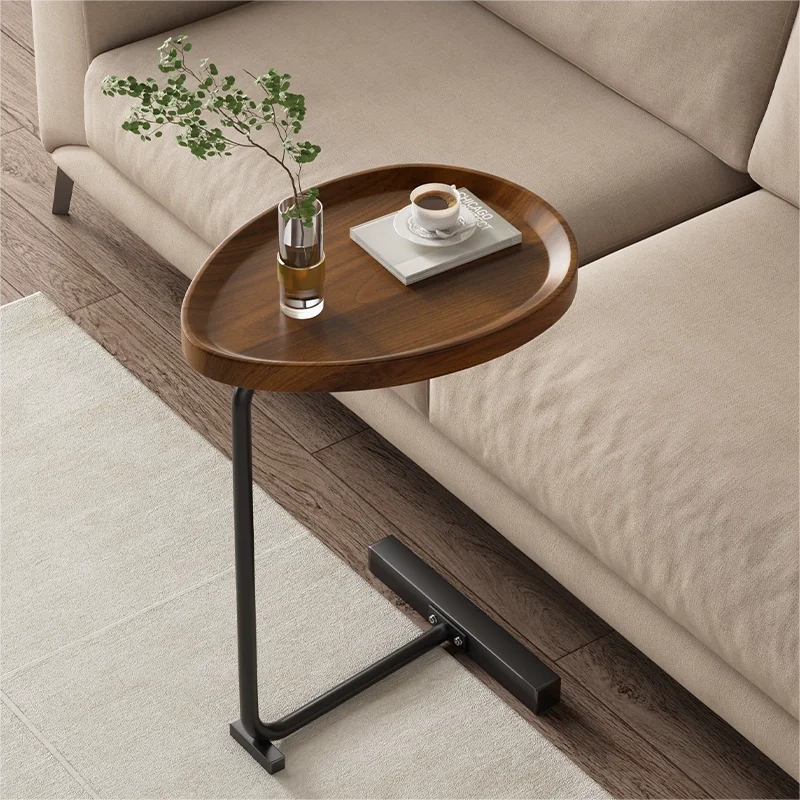 Fitlybuy modern C-shaped side table with a dark wood oval top and black metal base next to a beige living room sofa.