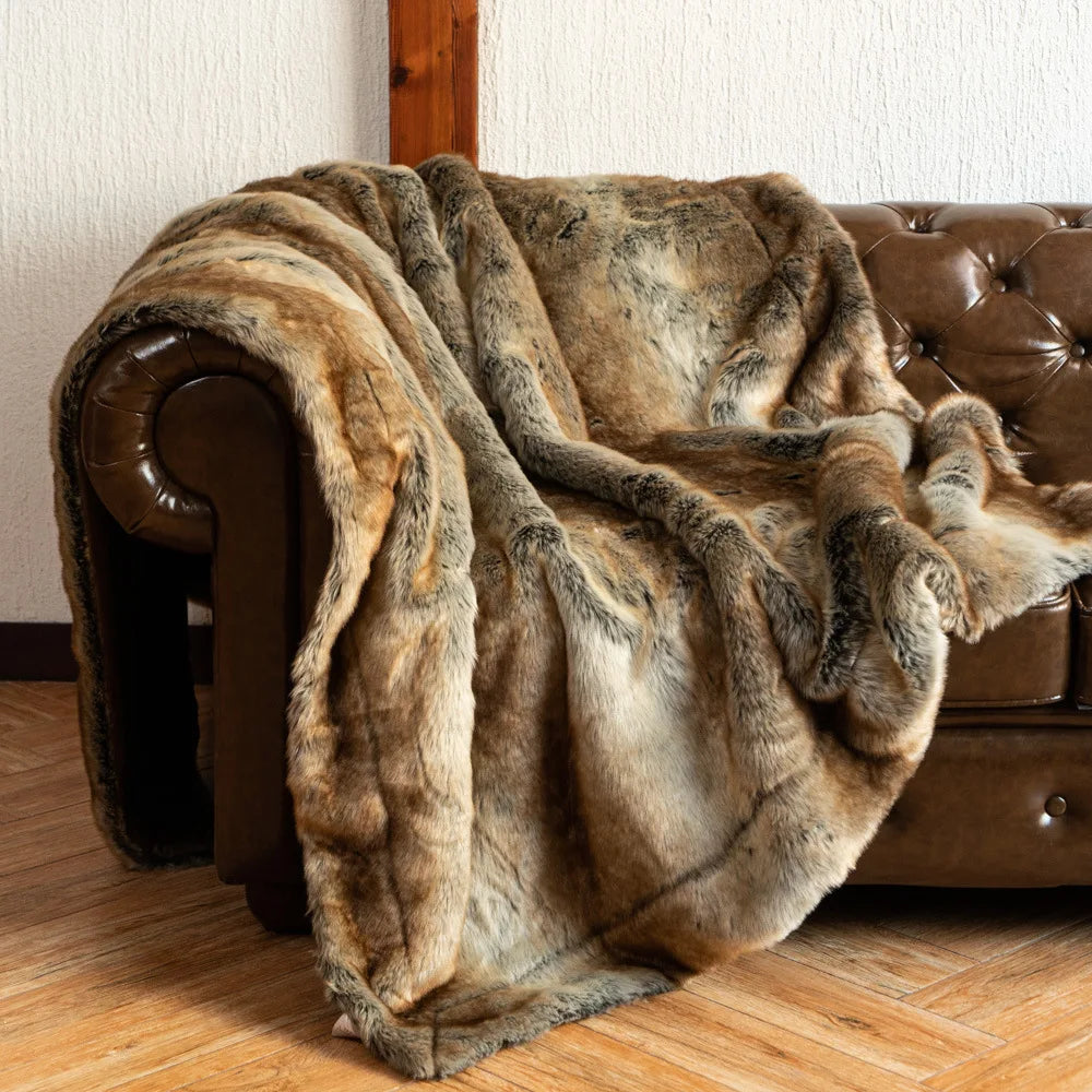 Fitlybuy luxury faux fox fur throw blanket with realistic brown and grey texture draped over a tufted leather sofa.