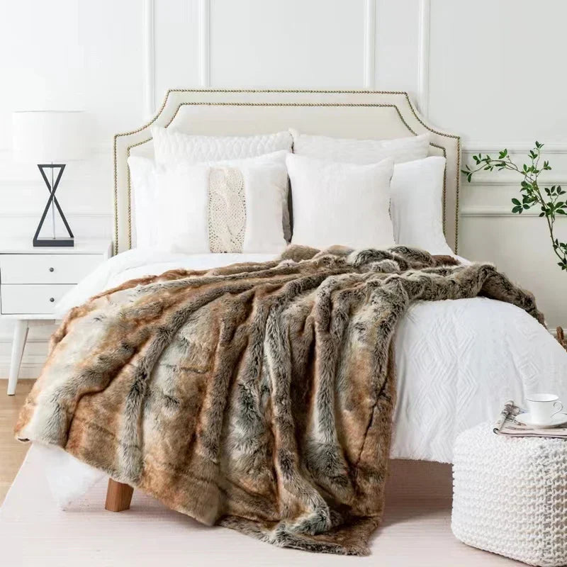 Luxurious brown and gray faux mink fur throw blanket draped over a white bed in a bright, modern bedroom.
