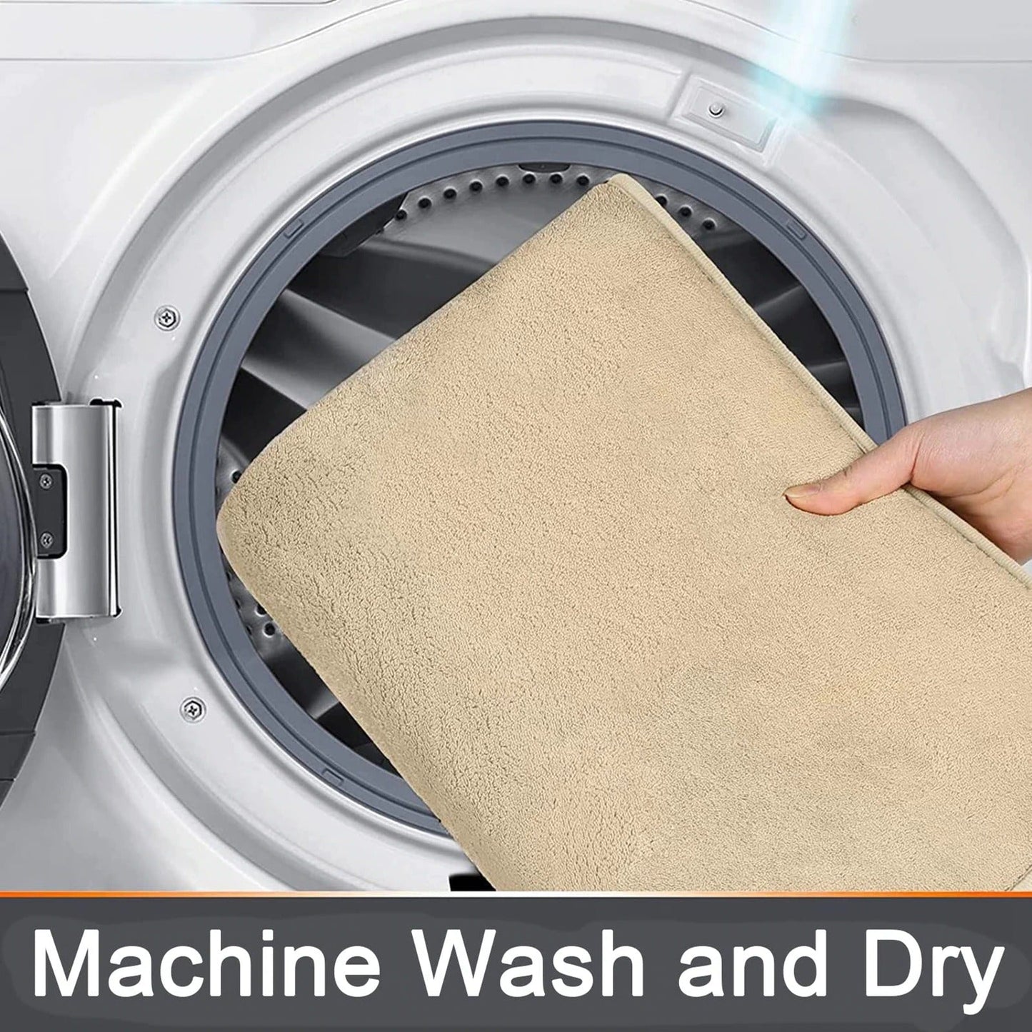 Hand placing a beige Fitlybuy memory foam bath mat into a washing machine for easy machine washing and drying.