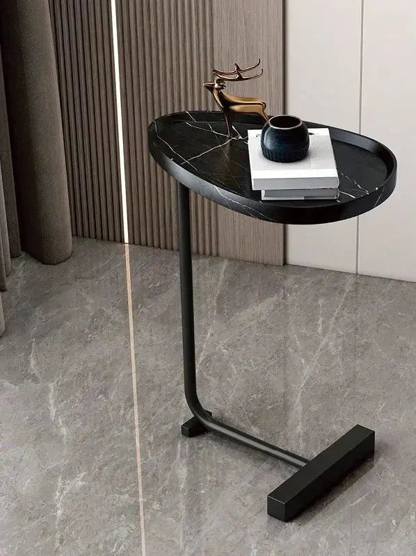 Modern Fitlybuy black marble oval C-table with metal frame on grey stone floor, styled with decor in a luxury room.