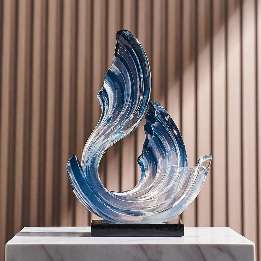 Fitlybuy Ethereal Flow blue glass ornament with a swirling, wave-like design on a black base and marble pedestal.