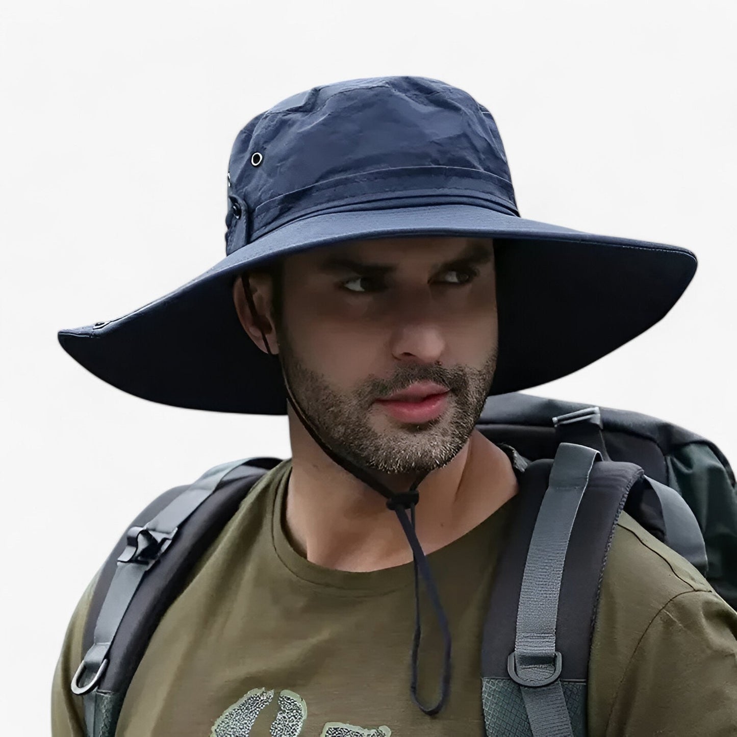 Man wearing a navy blue Fitlybuy Zeno UV protection sun hat with wide brim and chin strap while hiking with a backpack.