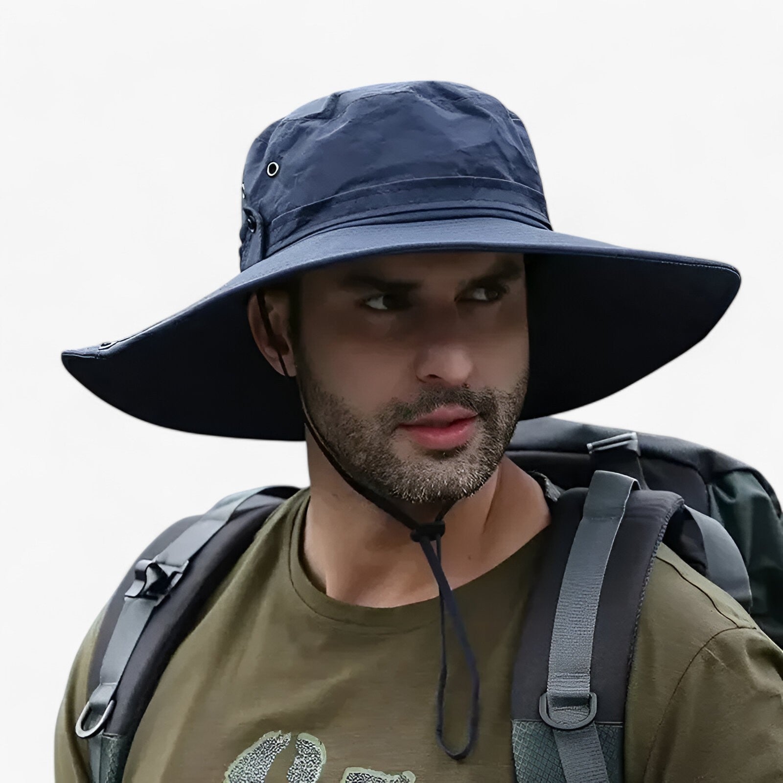 Man wearing a navy blue Fitlybuy Zeno UV protection sun hat with wide brim and chin strap while hiking with a backpack.