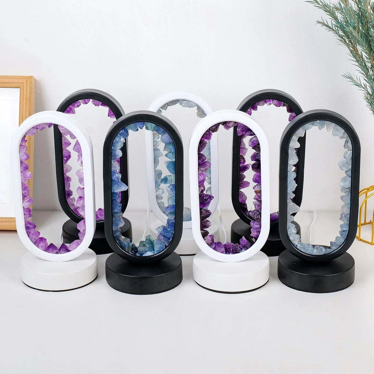 Fitlybuy AuraStone oval lamps with purple or blue raw crystals in black and white frames on a white surface.